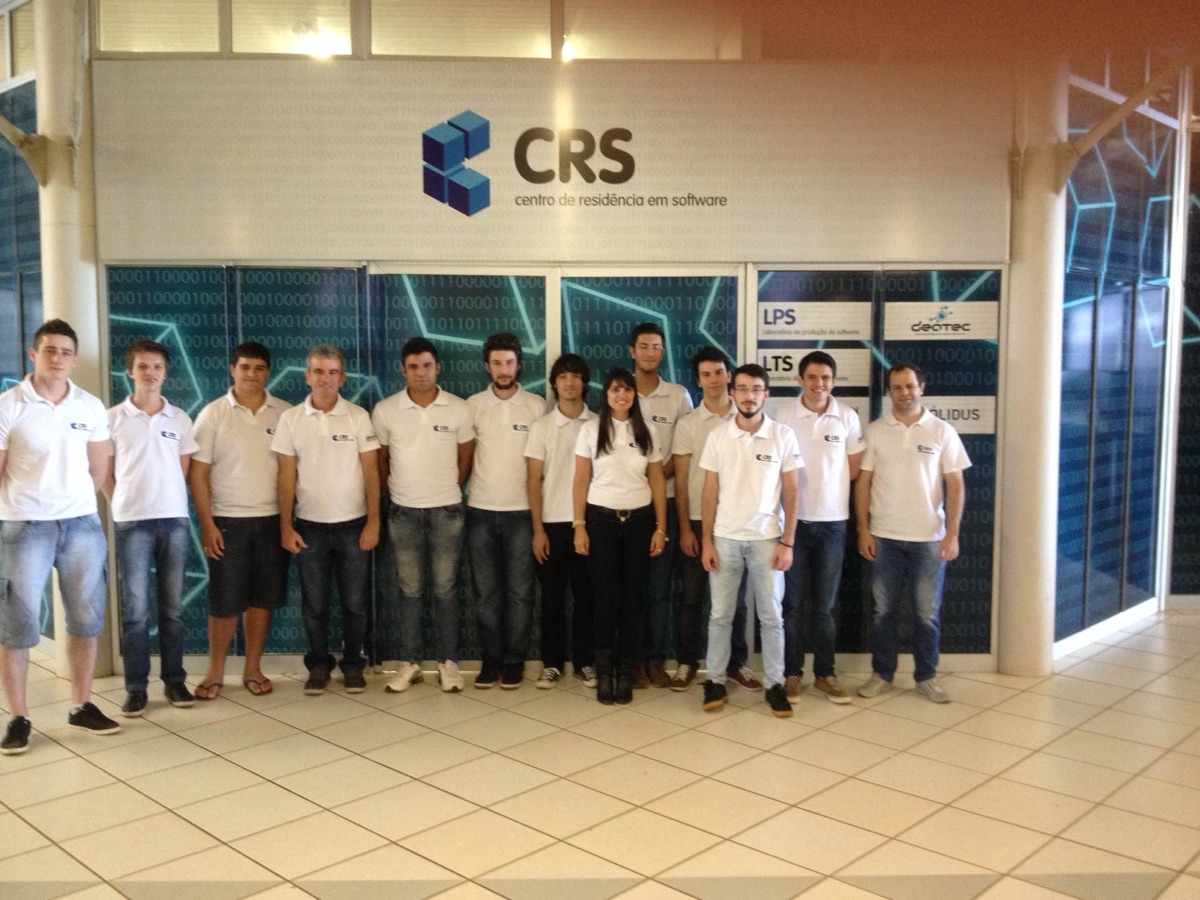 Turma de residentes de 2015 de corpo inteiro em frente ao mural com a marca CRS.